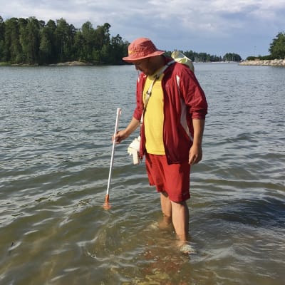 Tobias Lillqvist mäter temperaturen i strandvattnet.