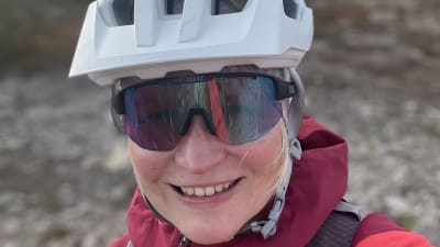 En portträttbild av en kvinna med cykelhjälm.