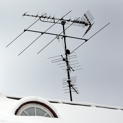 Tv-antenner på tak med gammal skorsten.