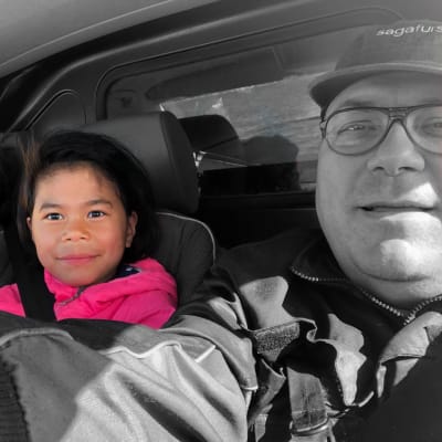 Familjen Nordmyr selfie i bil. Svartvit bild där dottern Samantha är i färg.