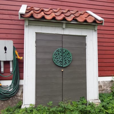 Ett litet förråd byggt mot en husfasad.
