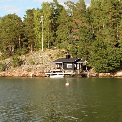 Sommarstuga med bastu och båt vid strandlinjen på Luonnonmaa i Nådendal.