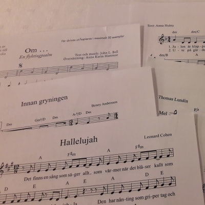 Närbild på notpapper till olika sånger som sjungs vid kören Kråksångens övning.