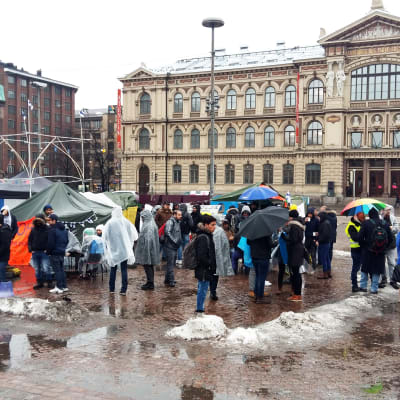 Demonstrerande asylsökande på Järnvägstorget i Helsingfors har satt upp ett par tält och banderoller.