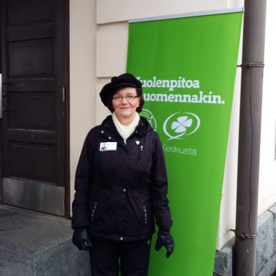 Kvinna framför Centerns reklamskylt.