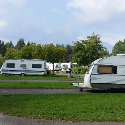 Asuntoautoja- ja vaunuja sekä henkilöauto Rauhalahden leirintäalueella.