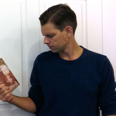 Alex Schulman håller i boken "Glöm mig".