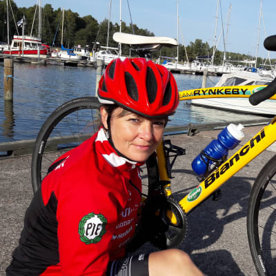 Mariella Ramstedt i full cykelutrustring bredvid sin begagnade Team Rynkeby-cykel
