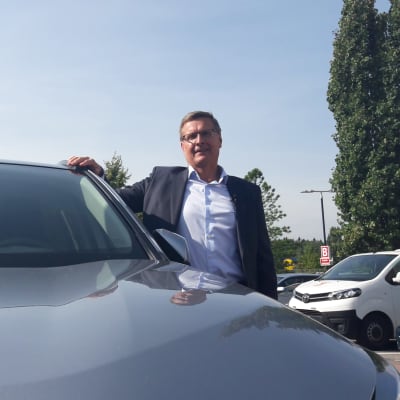 Vd Pekka Rissa vid Bilhandelns centralförbund poserar vid en bil. 