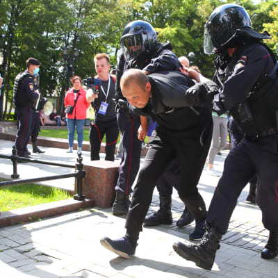 Poliser i Moskva för bort en demonstrant som visat stöd för demonstranterna i Chabarovsk.