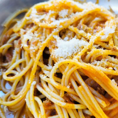 Närbild av spaghetti bolognese med parmesan på.