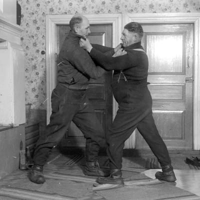 Två män leker "kragtag", där man ska försöka lägga sin motståndare på rygg, Man får bara hålla i den andras krage. Bilden är tagen 1937 i Korsnäs, Harrström.