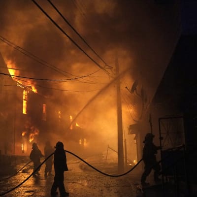 I den chilenska hamnstaden Valparaiso har minst 150 hus brunnit ner och tusentals männsikor har evakuerats undan en skogsbrand som har spridit sig till staden.
