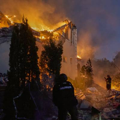Ett bostadshus brinner – brandmän försöker släcka elden.