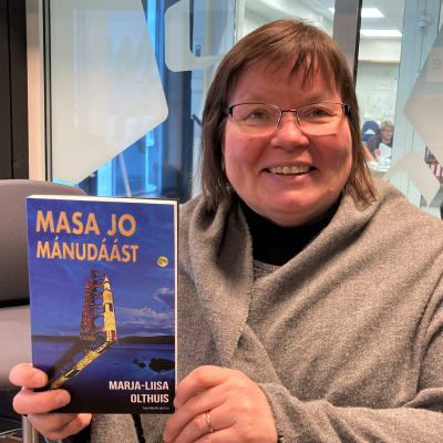 Marja-Liisa Olthuis pidtää kädessään kirjoittamansa Masa jo mánudáást kirja kädessä. 