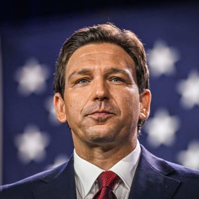 Ron DeSantis i närbild med en amerikansk flagga i bakgrunden.