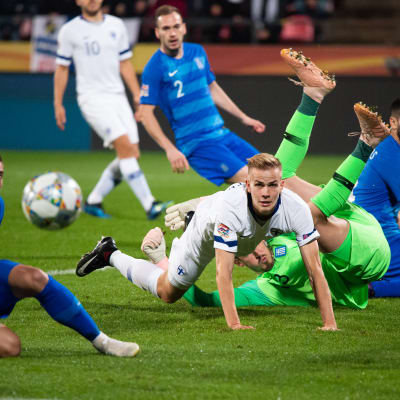 Suomen Jasse Tuominen kamppailee pallosta Kreikan pelaajia vastaan.