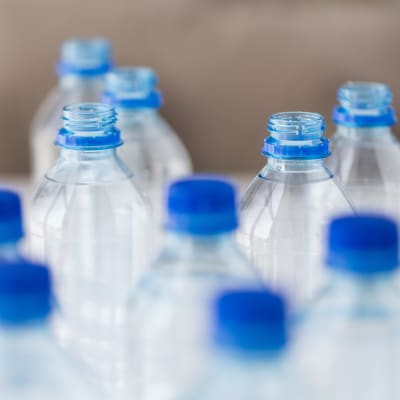 Vattenflaskor i plast med blå skruvkork.