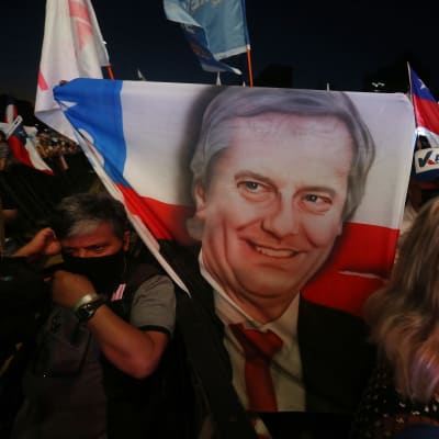 Chilessä laitaoikeiston presidenttiehdokkaan Jose Antonio Kastin kannattajat kantoivat kampanjatilaisuudessa ehdokkaan kuvalla varustettuja lippuja.