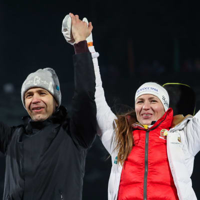 Ole Einar Björndalen och Darja Domratjeva sträcker upp armarna i luften
