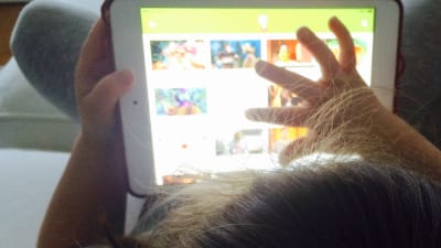 Flicka tittar på video på barnarenan