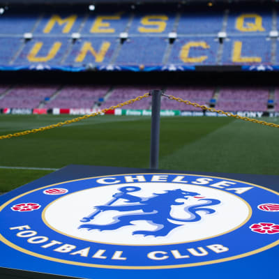 Chelsea FC:s logo med läktare i bakgrunden.