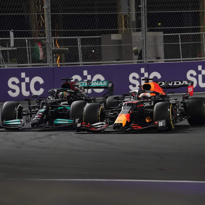 Lewis Hamilton och Max Verstappen kör i en kurva jämsides.