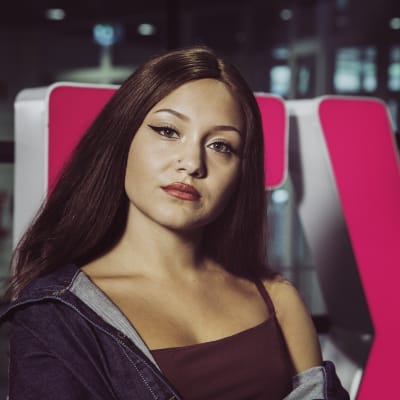 Laulaja ja räppäri Etta poseeraa YleX-kyltin edessä.