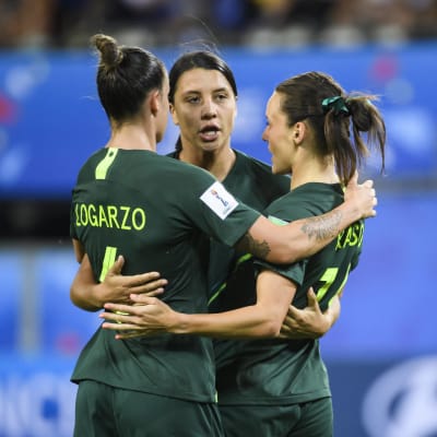 Tre australienska fotbollsspelare står i en ring.