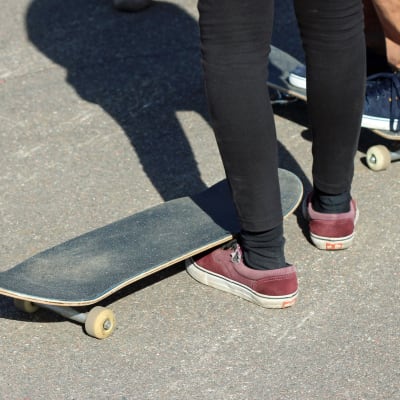 Fötterna på två ungdomar med skateboards.