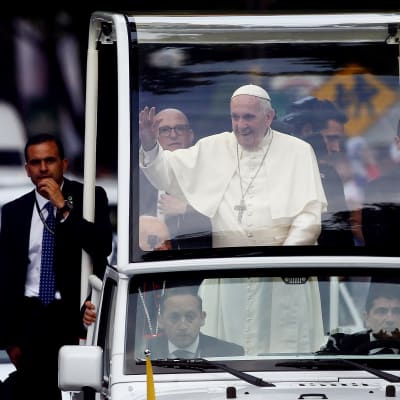 Påve Franciskus vinkar från sin påvemobil efter ankomsten till Santiago.
