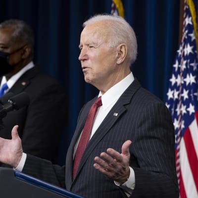 USA:s president Joe Biden håller tal och gestikulerar mer armarna. I bakgrunden står USA:s försvarsminister  Lloyd Austin