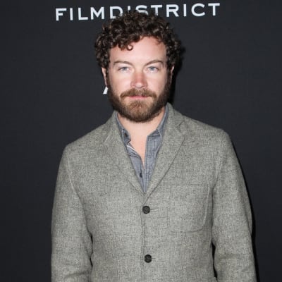 Danny Masterson poserar framför en svart vägg.