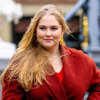 Prinsessan Catharina-Amalia av Nederländerna i röd kappa och svallande blont hår.