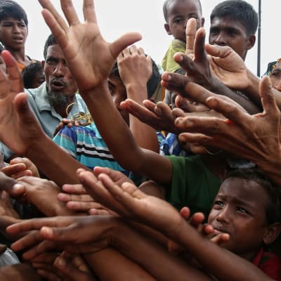 Flyktingar tillhörande rohingyafolket ber om mat i ett flyktingläger vid gränsen mellan Burma och Bangladesh.