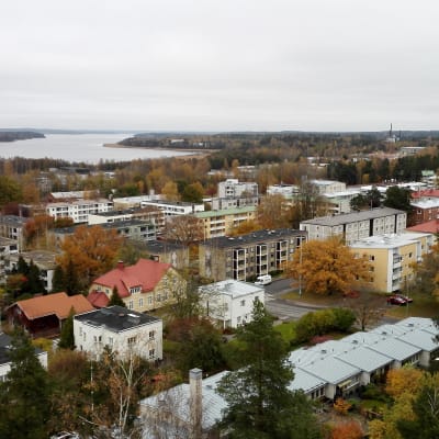 Vy över Ekenäs centrum tagen uppifrån. På bilden syns hustaken av flera höghus och till vänster i bild syns Pojoviken.