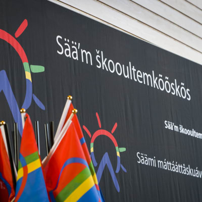 Saamelaisalueen koulutuskeskuksen logo ja saamenlippu