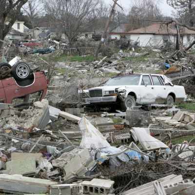 Skador efter stormen Katrina. En bil ligger på taket och en annan är kvaddad i ett hav av husrester.