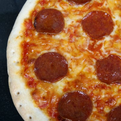 Närbild av en pizza med pepperoni.
