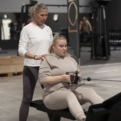 Personliga tränaren Anna Markelin Hjälper Rebecka Rahikainen att träna ryggmuskler på gym