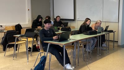 Studerande vid yrkesutbildning sitter och skriver på datorer.