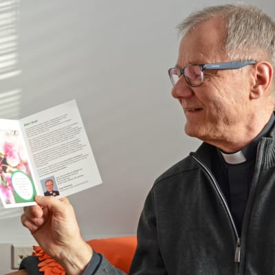 Roger Rönnberg kyrkoherde i Esbo svenska församling visar upp ett kort