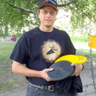 Ville Nivalaisen käsissä on frisbeegolfin uuden putterikiekon prototyyppejä.
