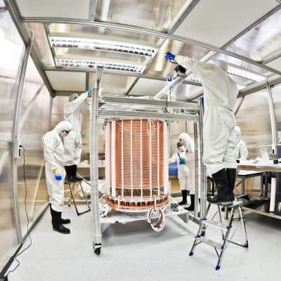 Tutkijat tarkastelevat jalokaasutankkia laboratoriossa.