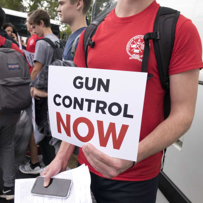Skolelev håller en skylt med krav på vapenkontroll. Han och andra elever är på väg till delstatens huvudstad Tallahassee för att framföra kravet på ökad vapenkontroll.