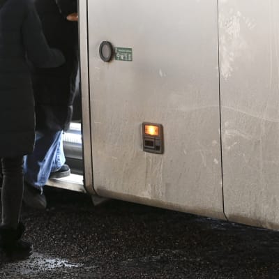 Flyktingar stiger på buss.