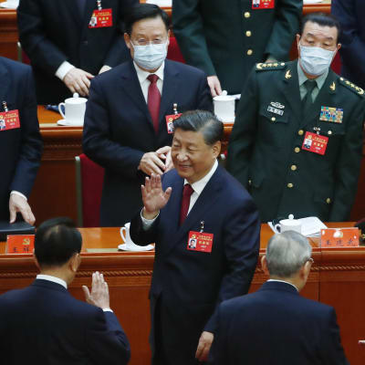 Xi Jinping vilkuttaa ympärillään seisoville kommunistipuolueen edustajille suuressa kansan salissa