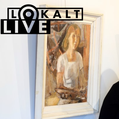 Sari Salo-Kiljo står bredvid ett självporträtt av Tove Jansson.