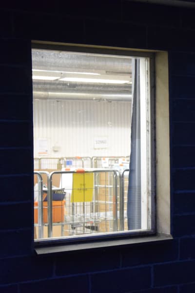 Två fönster i Hangö postterminal genom vilka man ser att verksamheten ligger nere.