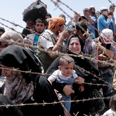 Syriska flyktingar väntar på att släppas in i Turkiet vid gränsen mellan Turkiet och Syrien.